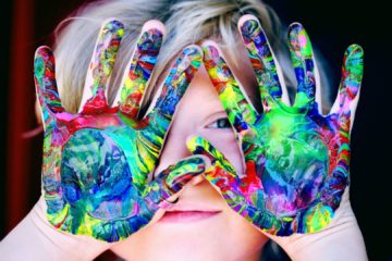 Les mains d'un enfant recouvertent de peinture après son activité manuelle préférée